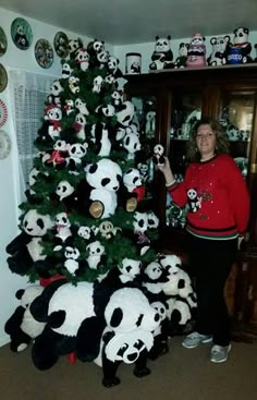 a woman standing next to a christmas tree with pandas on it and other stuffed animals