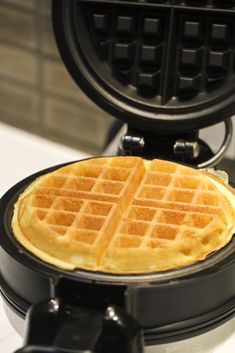 a waffle is sitting on top of a black pancake holder that has been placed on the counter