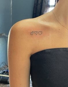 a woman with a heart tattoo on her shoulder and the word love written in cursive letters