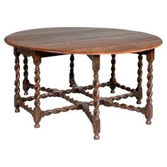 an old wooden table with twisted legs and a round wood table top on white background