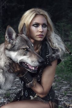 a woman with long blonde hair hugging a wolf