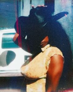 a woman wearing a black hat standing next to a white car