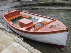 a small wooden boat sitting on the shore