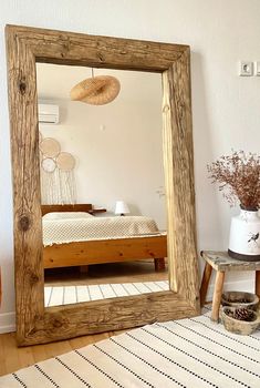 a large mirror sitting on top of a wooden floor