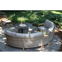 an outdoor seating area with two chairs and a fire pit in the middle of it