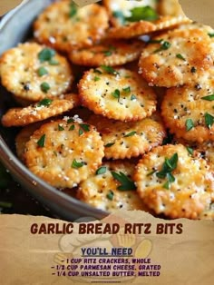 garlic bread ritz bites are in a bowl with herbs on top and seasoning around the edges