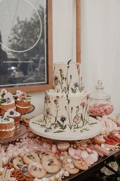 a table topped with lots of cakes and cookies