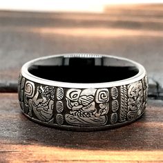 Exchange vows on your wedding day with this exclusive Custom Black Tungsten Ring with Ancient Aztec Symbols. The ring measures 8mm in width and is available from sizes 5 to 15. If you would like a matching ring in 6mm, please contact us. The ring is designed with a comfort fit interior. - Width - 8mm - Material - Tungsten Carbide - Color - Black, Silver - Sizes - 5 to 15 - Finish- High Polished Interior, Matte Exterior - Free Laser Engraving - Free Gift Box - Hypoallergenic To see more ring desi Aztec Wedding, Aztec Rings, Aztec Symbols, Ancient Aztecs, Black Tungsten Rings, Tungsten Mens Rings, Silver Ring Designs, Black Tungsten, Matching Ring