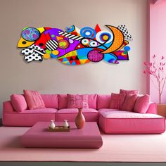 a living room with pink couches and colorful artwork on the wall above it's coffee table