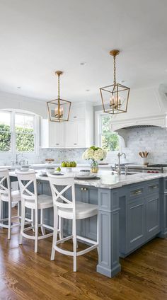 a kitchen with white cabinets and blue island