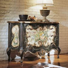 an ornately decorated cabinet with a lamp on top and a cowhide rug underneath