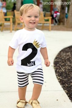 a little boy that is standing in the street wearing some kind of t - shirt