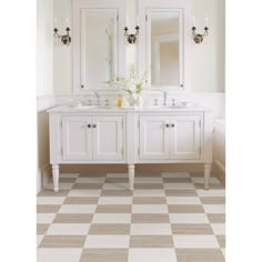 a bathroom with two sinks, mirrors and checkered flooring on the wall in front of it