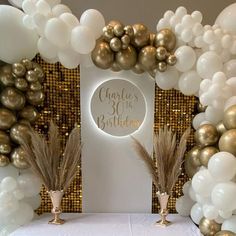 a table topped with white and gold balloons