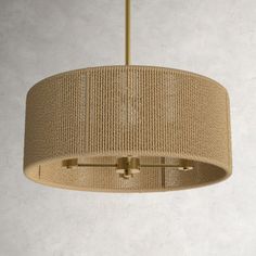 a light fixture hanging from a ceiling with a beige fabric covering on the top and bottom