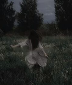 a woman in a white dress is running through the grass