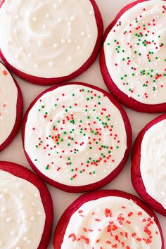 red velvet cookies with white frosting and sprinkles are arranged on a plate