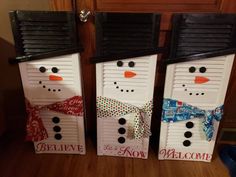 three snowmen made out of shutters sitting on top of a wooden floor