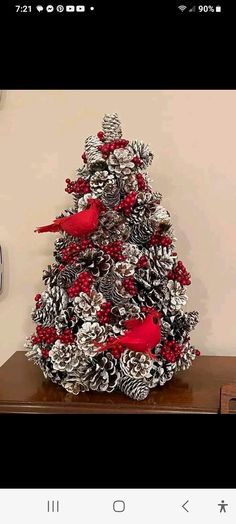 a christmas tree made out of pine cones and red birds