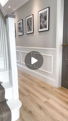 an empty room with pictures on the wall and stairs leading up to it's entrance