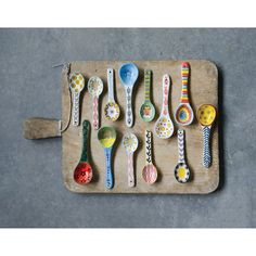 spoons are lined up on a tray with different designs and colors, all sitting side by side