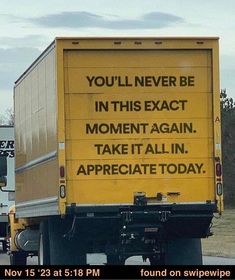 a yellow truck driving down a road with a message on the back