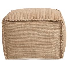 a beige ottoman with braiding on the sides and a square cushion in the middle