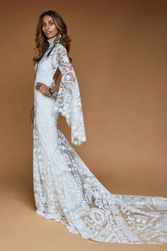 a woman in a white wedding dress posing for a photo with her hands on her hips