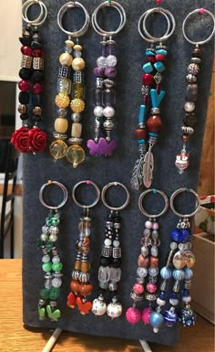 several different types of bracelets are hanging on a display rack in front of a table