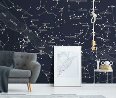 a room with a chair and wallpaper that has stars in the sky on it