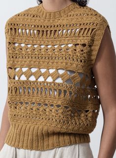 a woman wearing a brown crocheted sweater