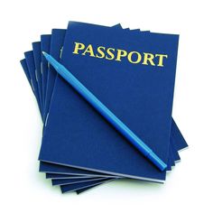 a stack of blue passport sitting on top of each other next to a blue pen