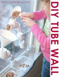 a kid is playing with some cups and bowls