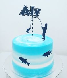 there is a blue cake with white frosting and black silhouettes on the top