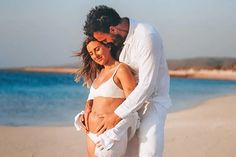 a man and woman embracing on the beach