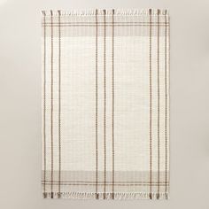 a white and brown plaid blanket hanging on a wall