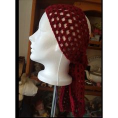 a white mannequin head wearing a red crocheted hat