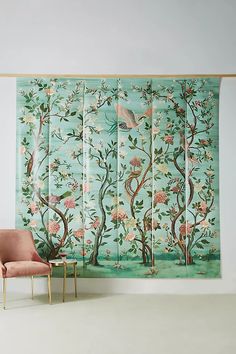 a room divider with birds and flowers on it, next to a pink chair