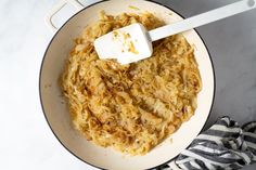 the food is being cooked in the pan with a spatula on top of it