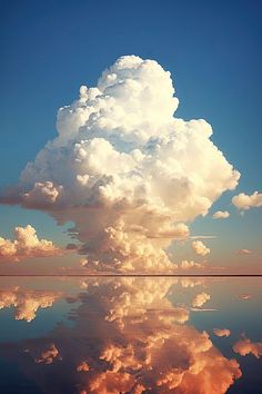 a large cloud is in the sky above water and clouds are reflected on the surface