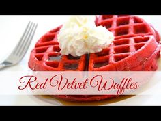 red velvet waffles with whipped cream on top and fork next to the waffle