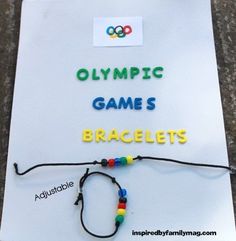 the olympic game is bracelets made from beads and plastic letters on a piece of paper