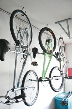 there are two bikes hanging on the wall and one is upside down in the garage