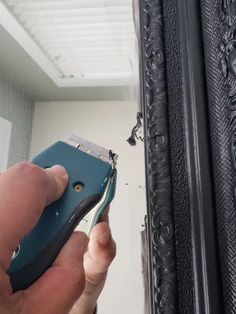 a person is holding a cordless phone in front of a mirror that has been damaged