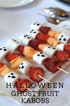 halloween treats are arranged on skewers with marshmallows and strawberries