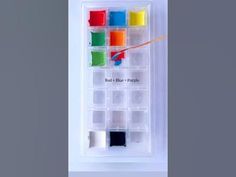 the box contains several different colored paints and one is holding a paintbrush with an eraser