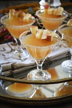 three glasses filled with fruit sitting on top of a glass tray next to each other