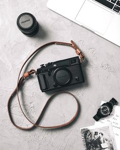 an old camera sitting on top of a table next to a laptop and other items