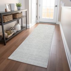 a white rug is on the floor in front of a door and shelf with baskets