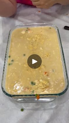 a glass casserole dish filled with food on top of a white tablecloth